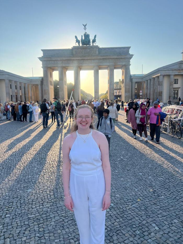 A student standing in front of the Brandenburg Gate in Berlin.